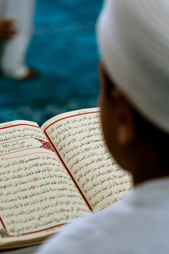 A child reads the Quran inside a mosque, highlighting spiritual devotion and cultural tradition.