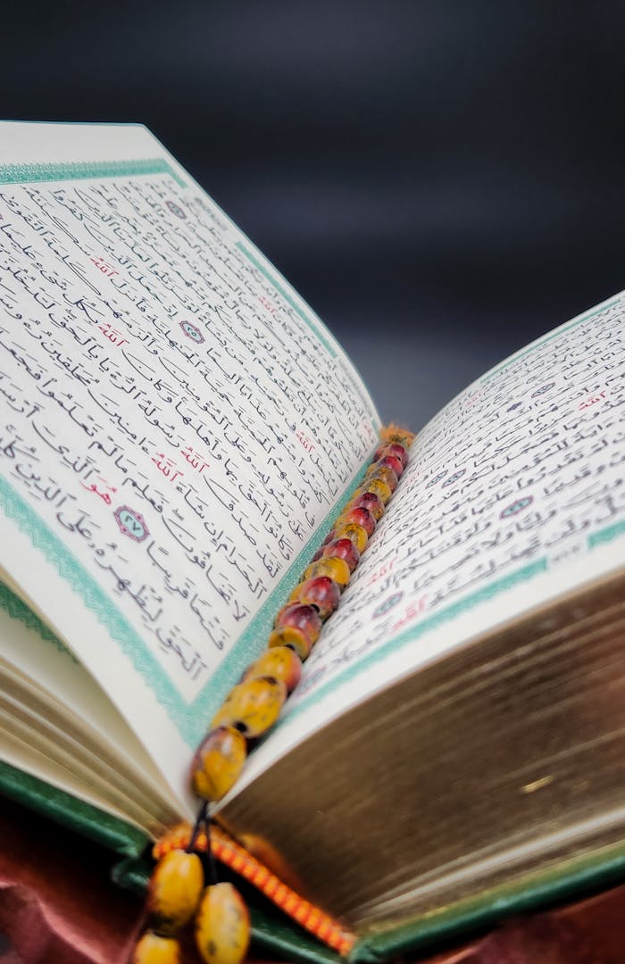 An open Quran with prayer beads resting on its pages, symbolizing spiritual devotion.